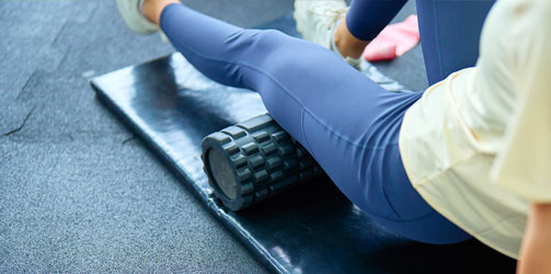 Woman foam rolling knee